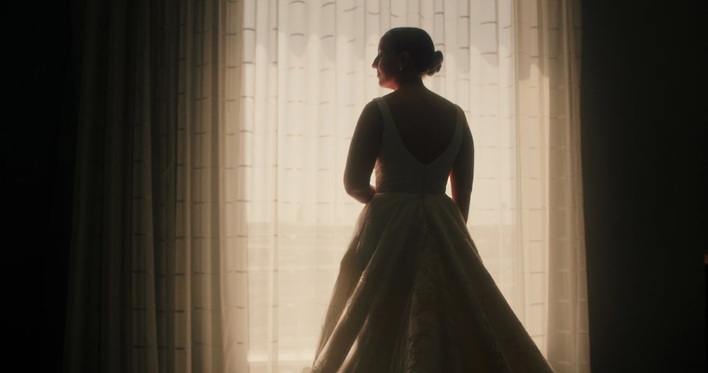 Bride in gown before sheer curtains, soft backlight—still from Alvaro & Jen's wedding film, Leviathan Film